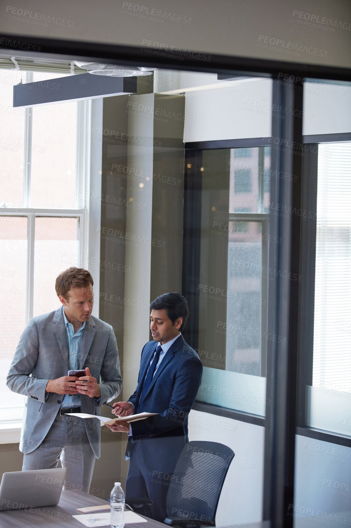 Buy stock photo Cropped shot of businessmen looking at paperwork in their office