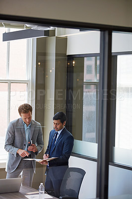 Buy stock photo Cropped shot of businessmen looking at paperwork in their office