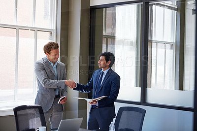 Buy stock photo Cropped shot of two businessmen shaking hands in the office