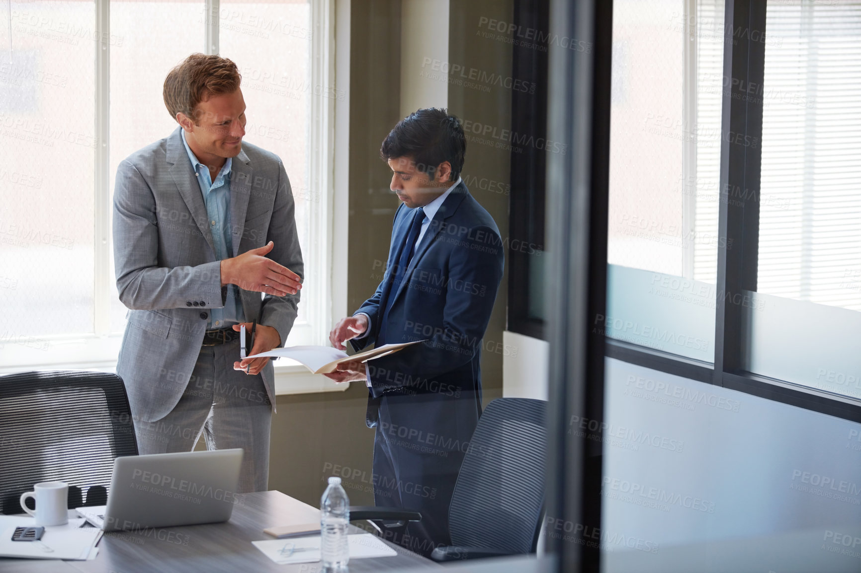 Buy stock photo Cropped shot of two businessmen shaking hands in the office