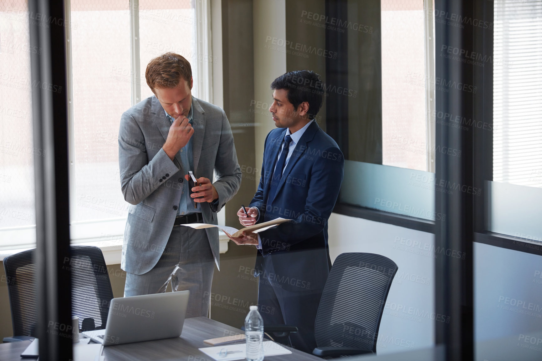 Buy stock photo Cropped shot of businessmen looking at paperwork in their office