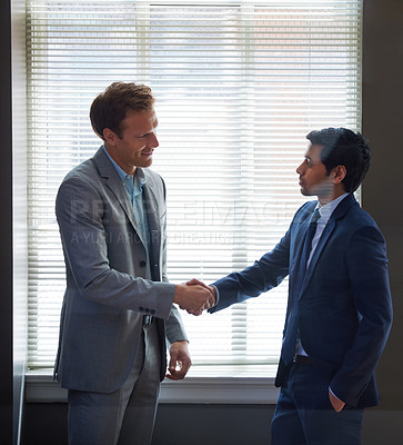 Buy stock photo Cropped shot of two businessmen shaking hands in the office