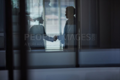 Buy stock photo Cropped shot of two businessmen shaking hands in the office