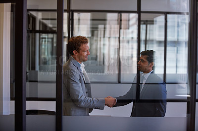 Buy stock photo Cropped shot of two businessmen shaking hands in the office