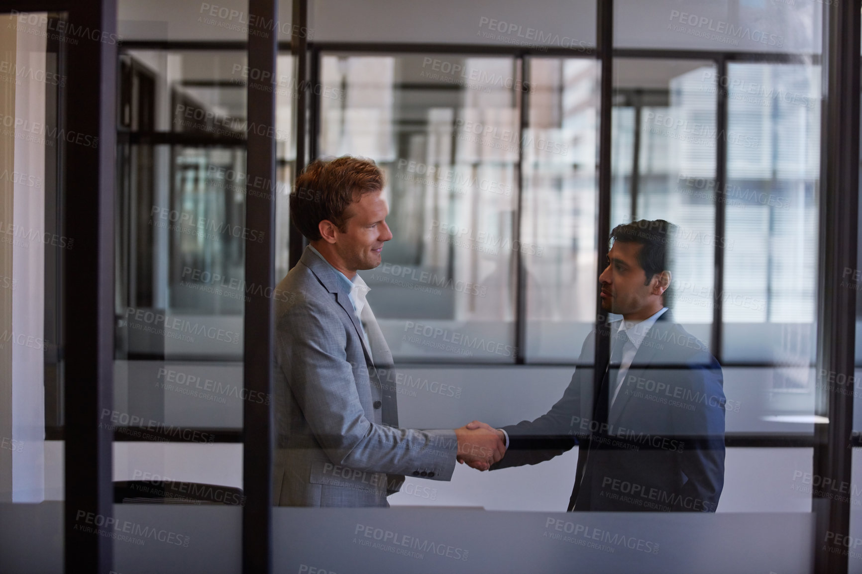 Buy stock photo Cropped shot of two businessmen shaking hands in the office