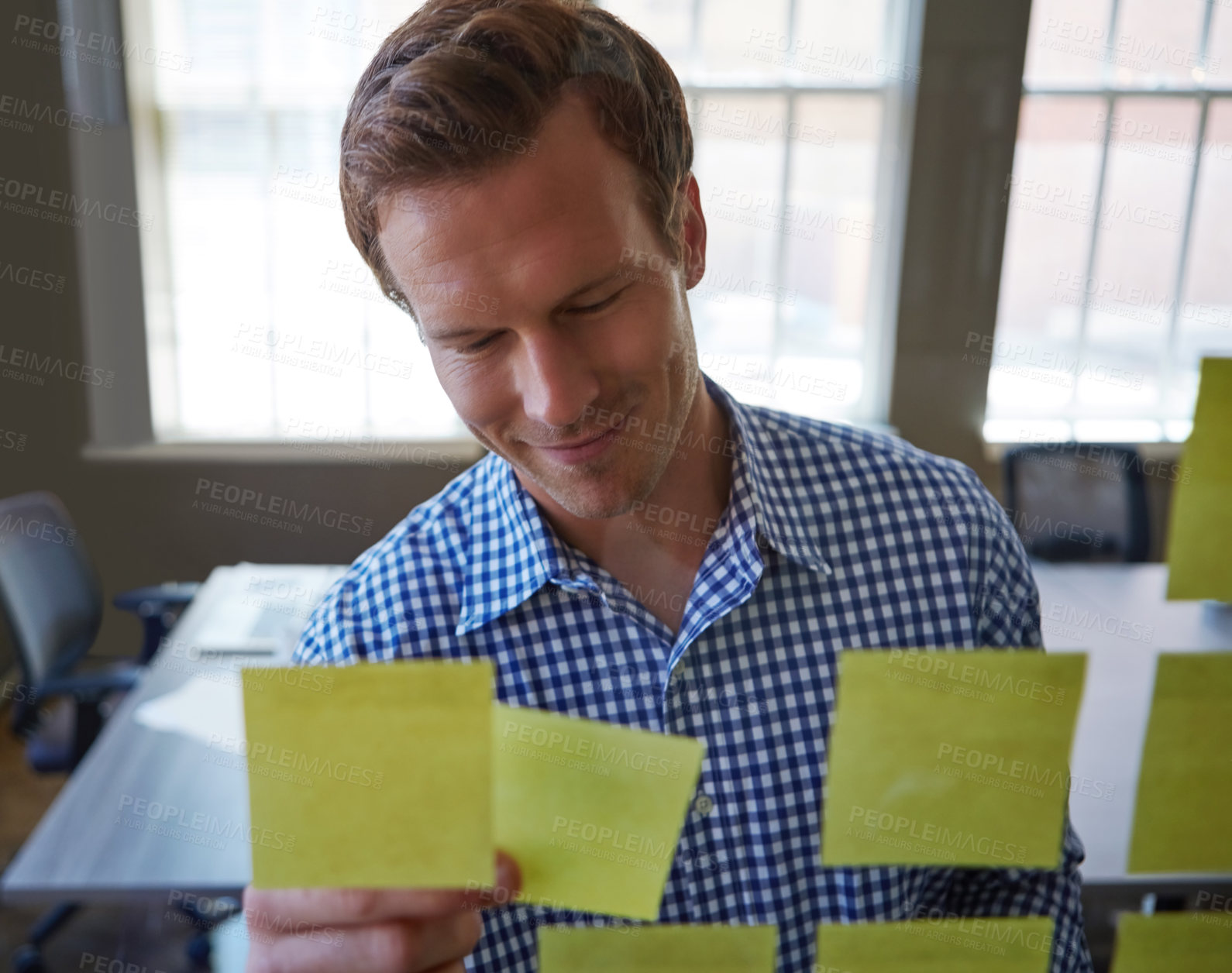 Buy stock photo Cropped shot of a handsome businessman arranging adhesive notes on a glass pane