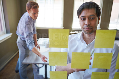 Buy stock photo Cropped shot of two businessmen preparing for a presentation by using adhesive notes