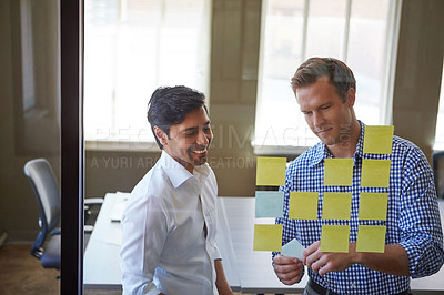 Buy stock photo Cropped shot of two businessmen preparing for a presentation by using adhesive notes