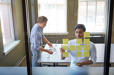 Buy stock photo Cropped shot of two businessmen preparing for a presentation by using adhesive notes