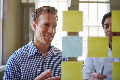 Buy stock photo Cropped shot of two businessmen preparing for a presentation by using adhesive notes