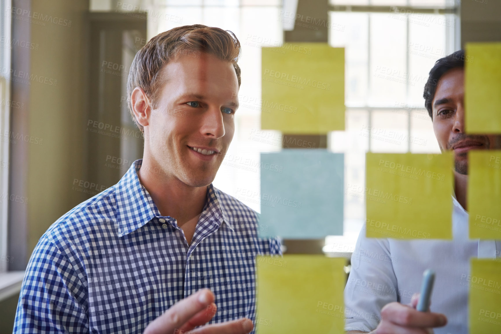 Buy stock photo Cropped shot of two businessmen preparing for a presentation by using adhesive notes