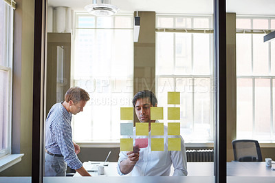 Buy stock photo Cropped shot of two businessmen preparing for a presentation by using adhesive notes