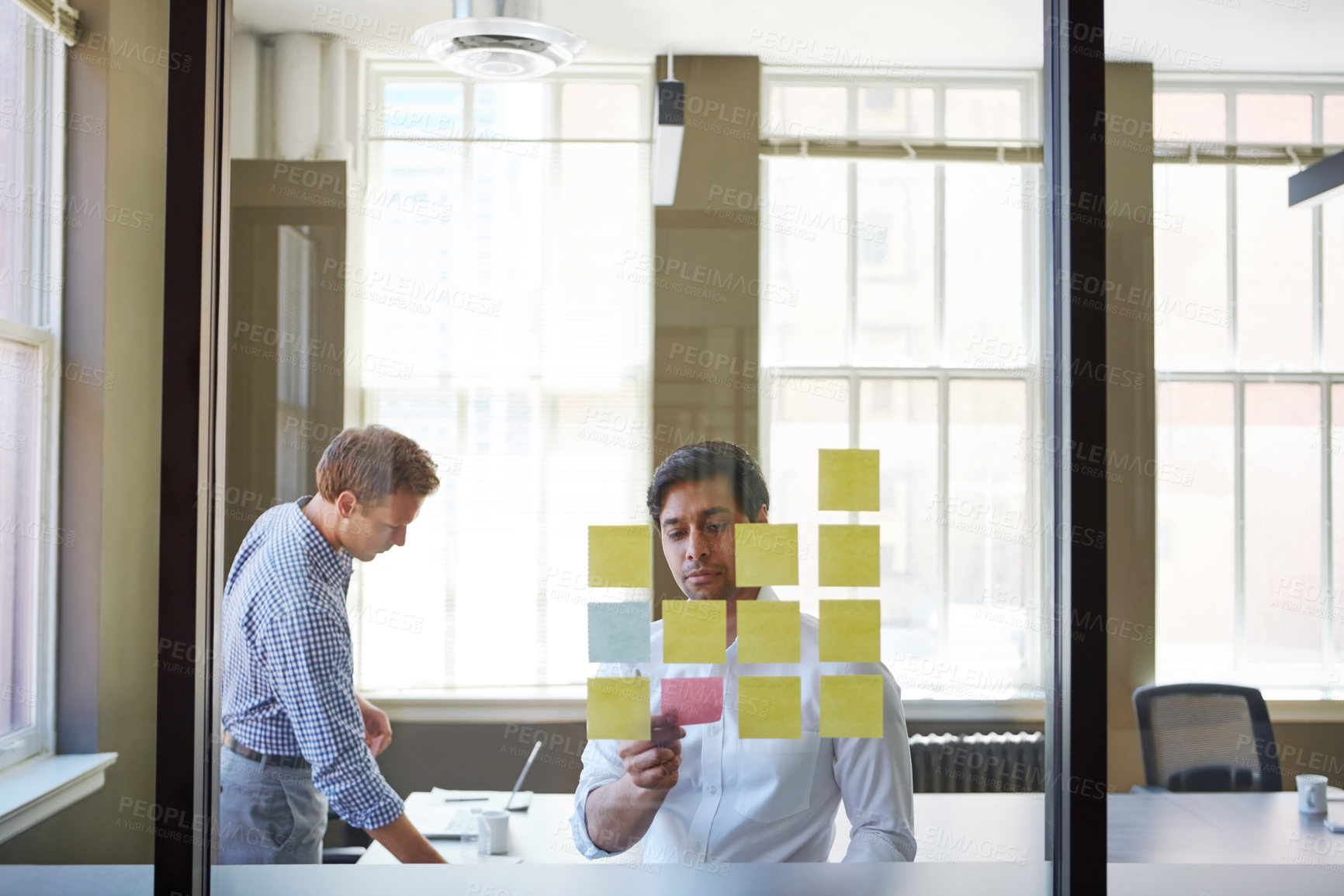 Buy stock photo Cropped shot of two businessmen preparing for a presentation by using adhesive notes