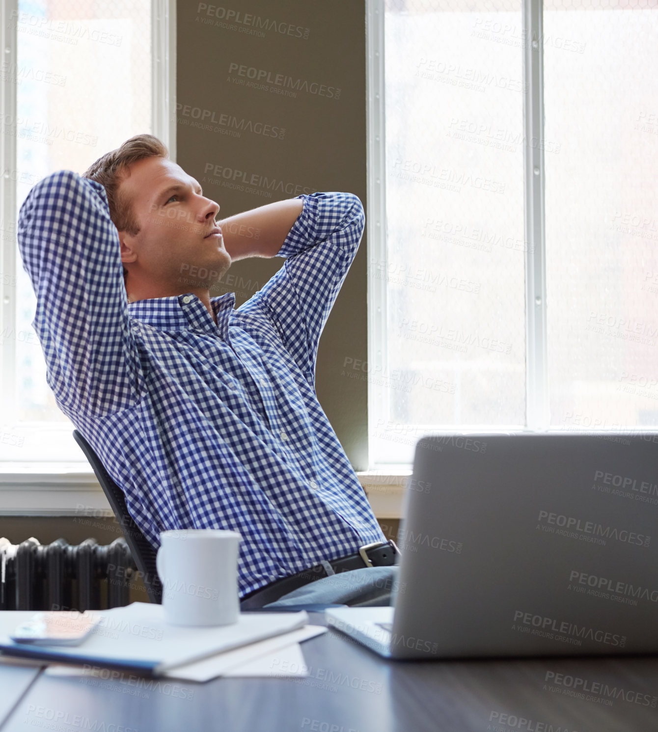 Buy stock photo Shot of a worried businessman leaning back in his chair