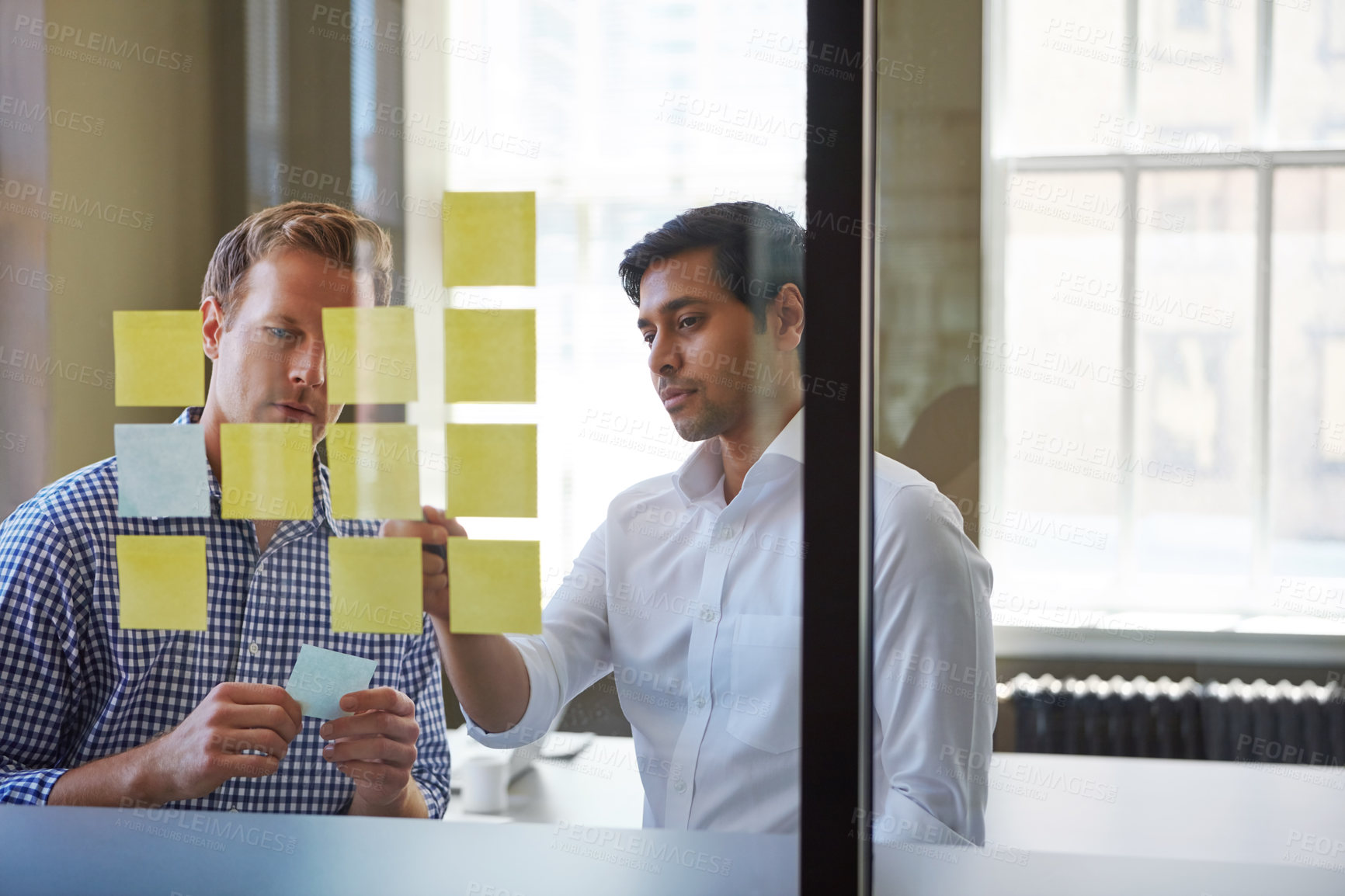 Buy stock photo Cropped shot of two businessmen preparing for a presentation by using adhesive notes