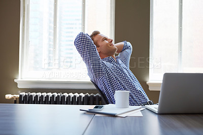 Buy stock photo Shot of a happy businessman leaning back in his chair