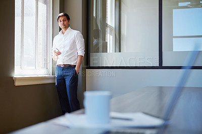 Buy stock photo Shot of a businessman working on his smartphone in the office