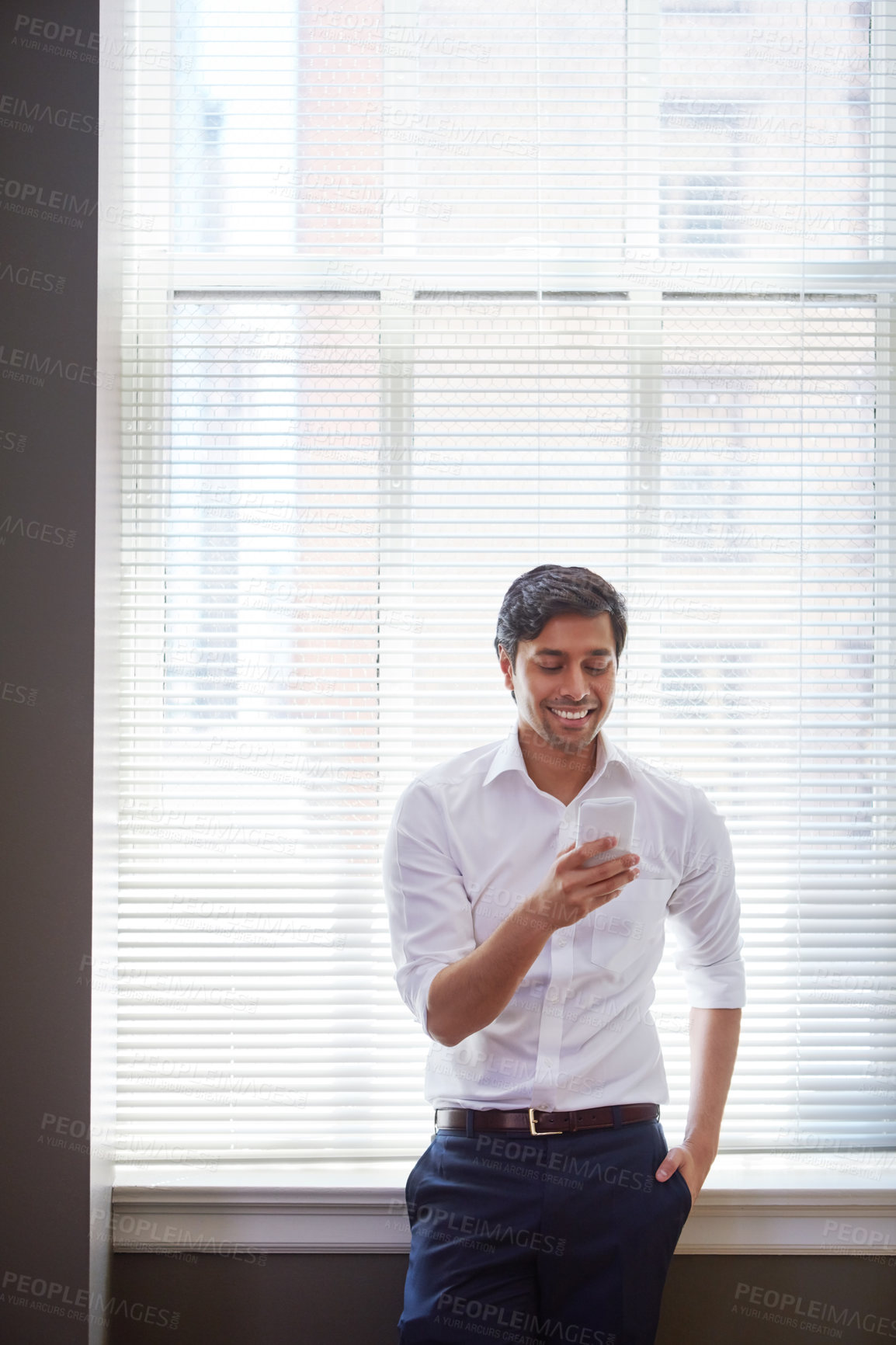 Buy stock photo Business, man and smile with phone in office for real estate, property research and auction listing. Male realtor, mobile and feedback on expansion negotiation, contact client and viewing opportunity