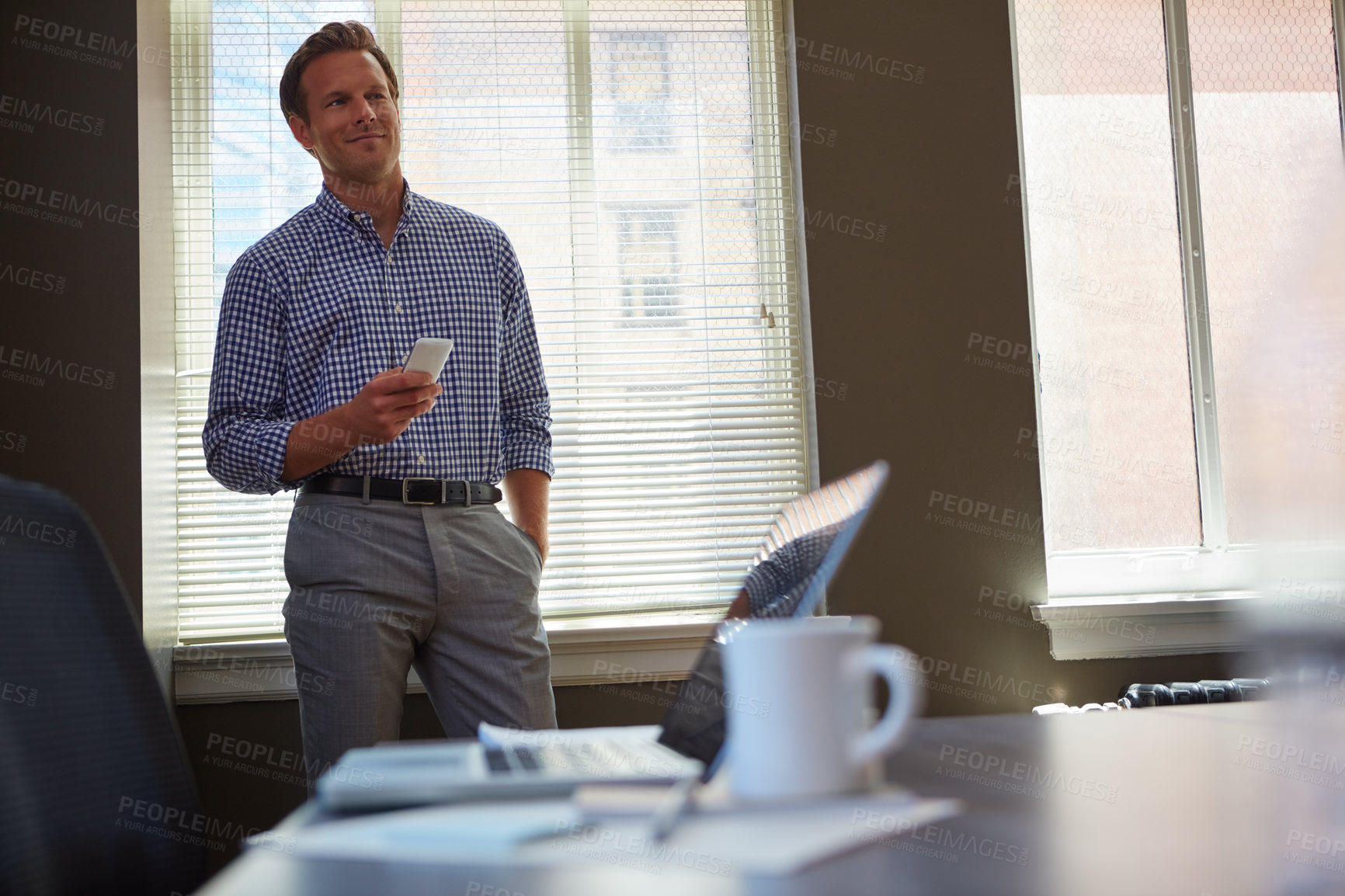 Buy stock photo Shot of a businessman working on his smartphone in the office