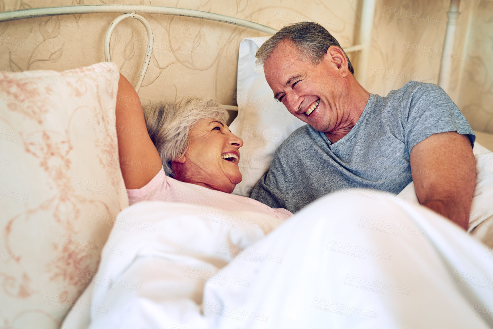 Buy stock photo Cropped shot of a senior couple being affectionate in their bedroom