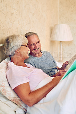 Buy stock photo Cropped shot of a senior couple reading in bed together