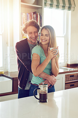 Buy stock photo Love, hug and happy couple with coffee in kitchen for connection, morning romance and marriage in home. Smile, man and woman embrace with drink beverage for support, loyalty and bonding with partner