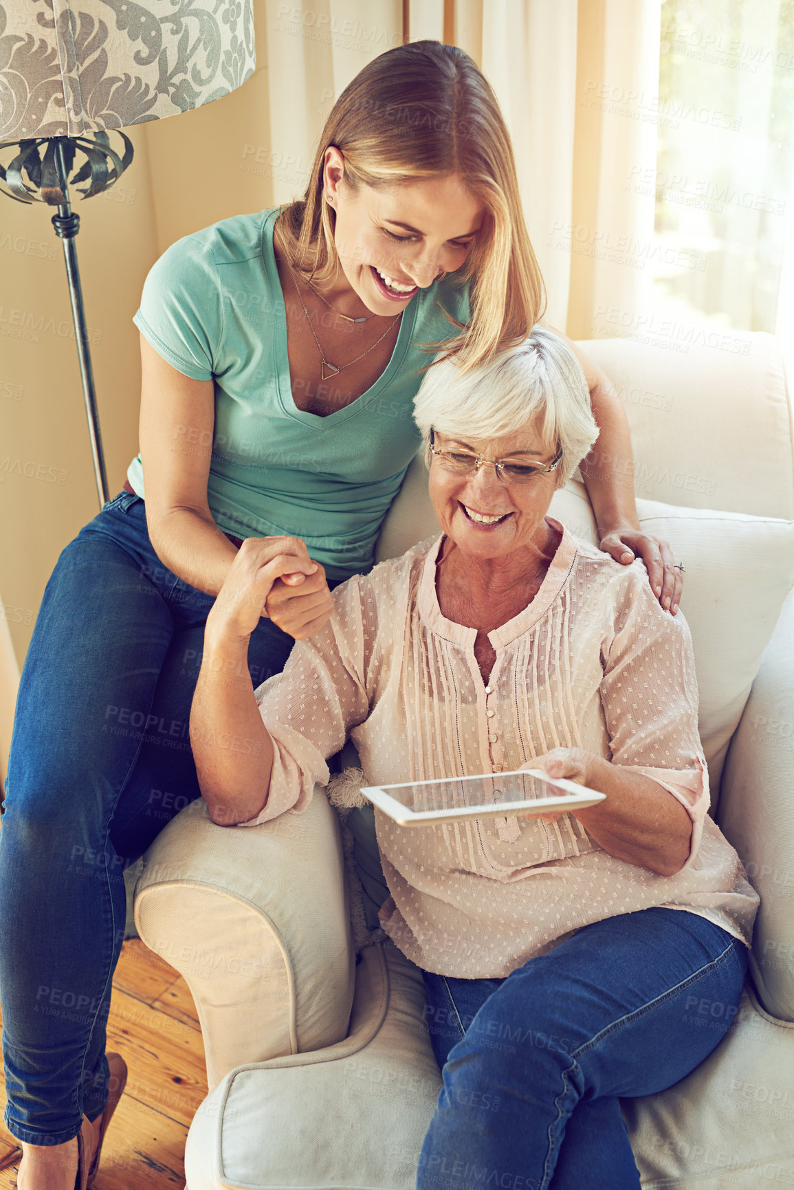Buy stock photo Shot of a woman showing her elderly mother how to use a tablet at home