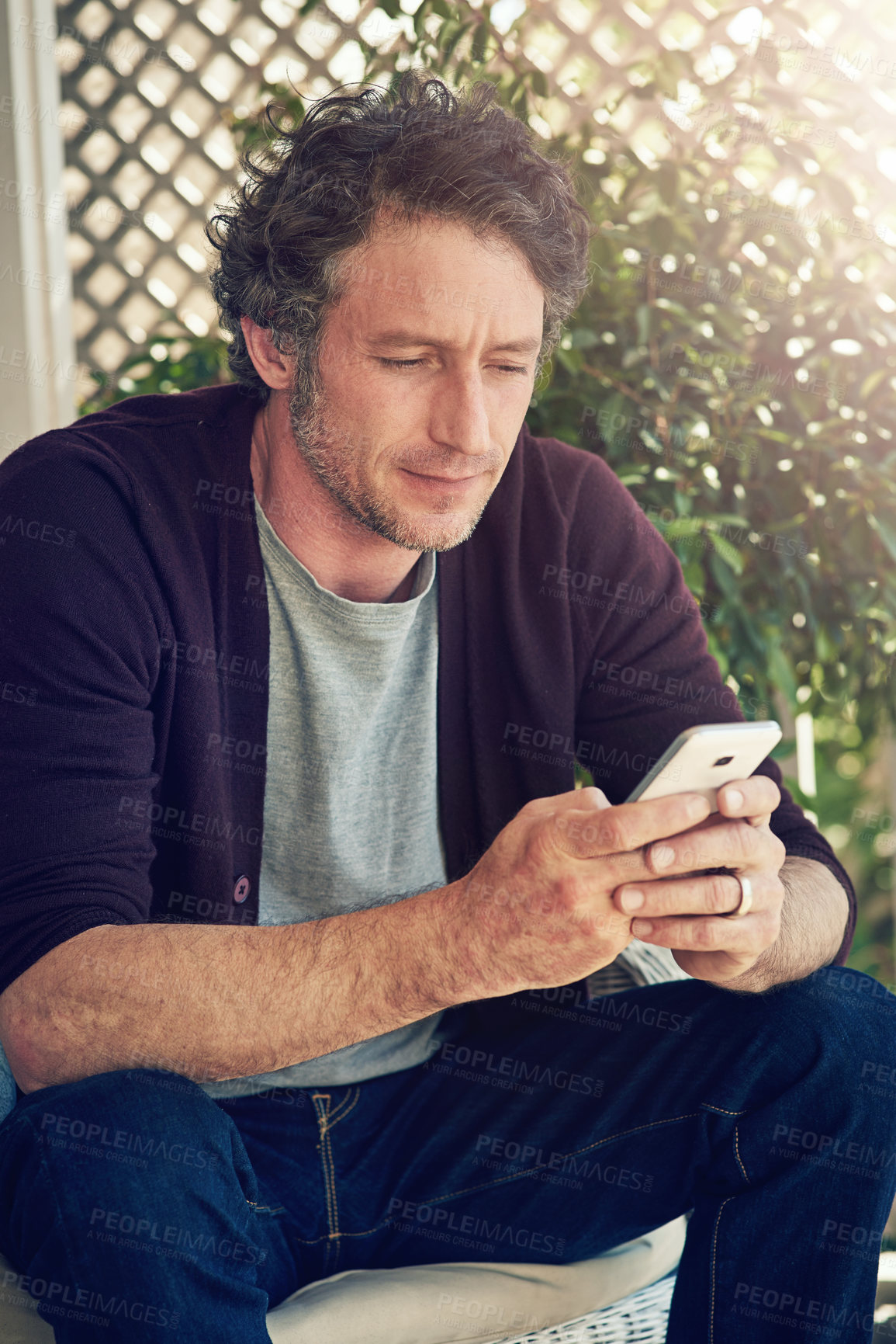 Buy stock photo Cropped shot of a man using his smartphone outside his home