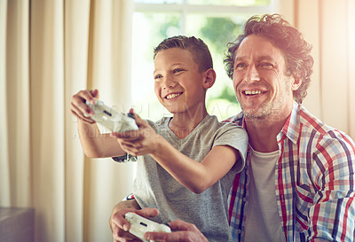 Buy stock photo Cropped shot of a father and his son playing video games at home