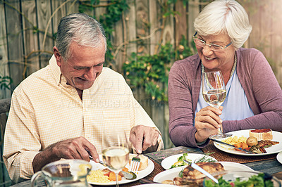 Buy stock photo Shot of a happy senior couple having lunch together outdoors