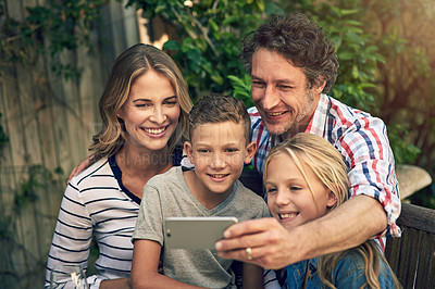 Buy stock photo Shot of a happy family taking a selfie together in their backyard