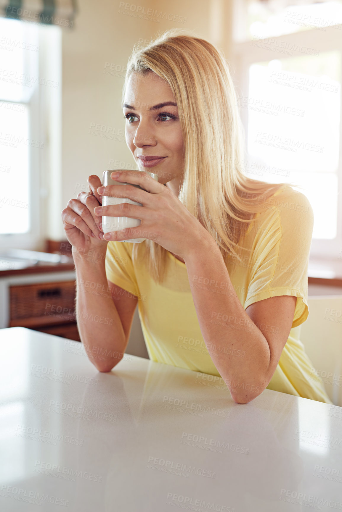 Buy stock photo Cropped shot of a woman drinking coffee in her kitchen at home