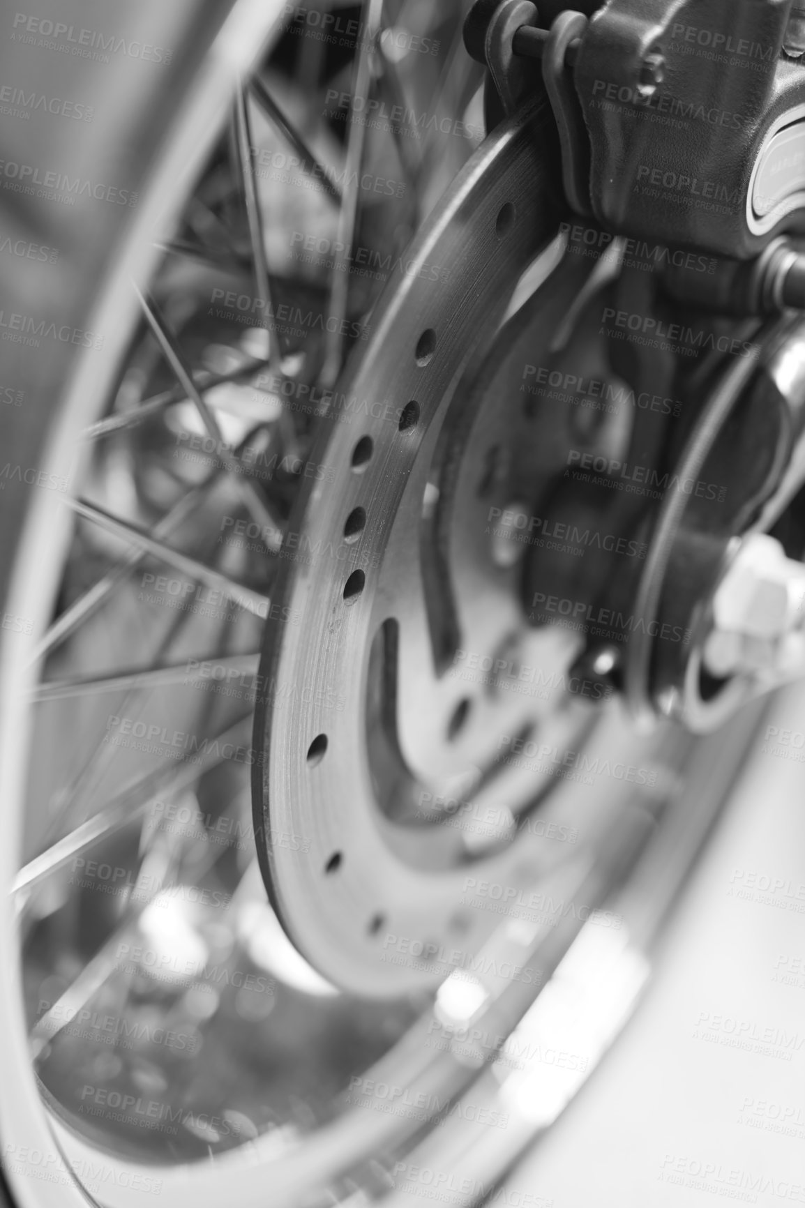 Buy stock photo Antique chrome wheel with multiple spokes on a motorbike in black and white. Closeup of a shiny disk on a well maintained motorcycle. Detail of a metal rim on an old vintage retro bike background
