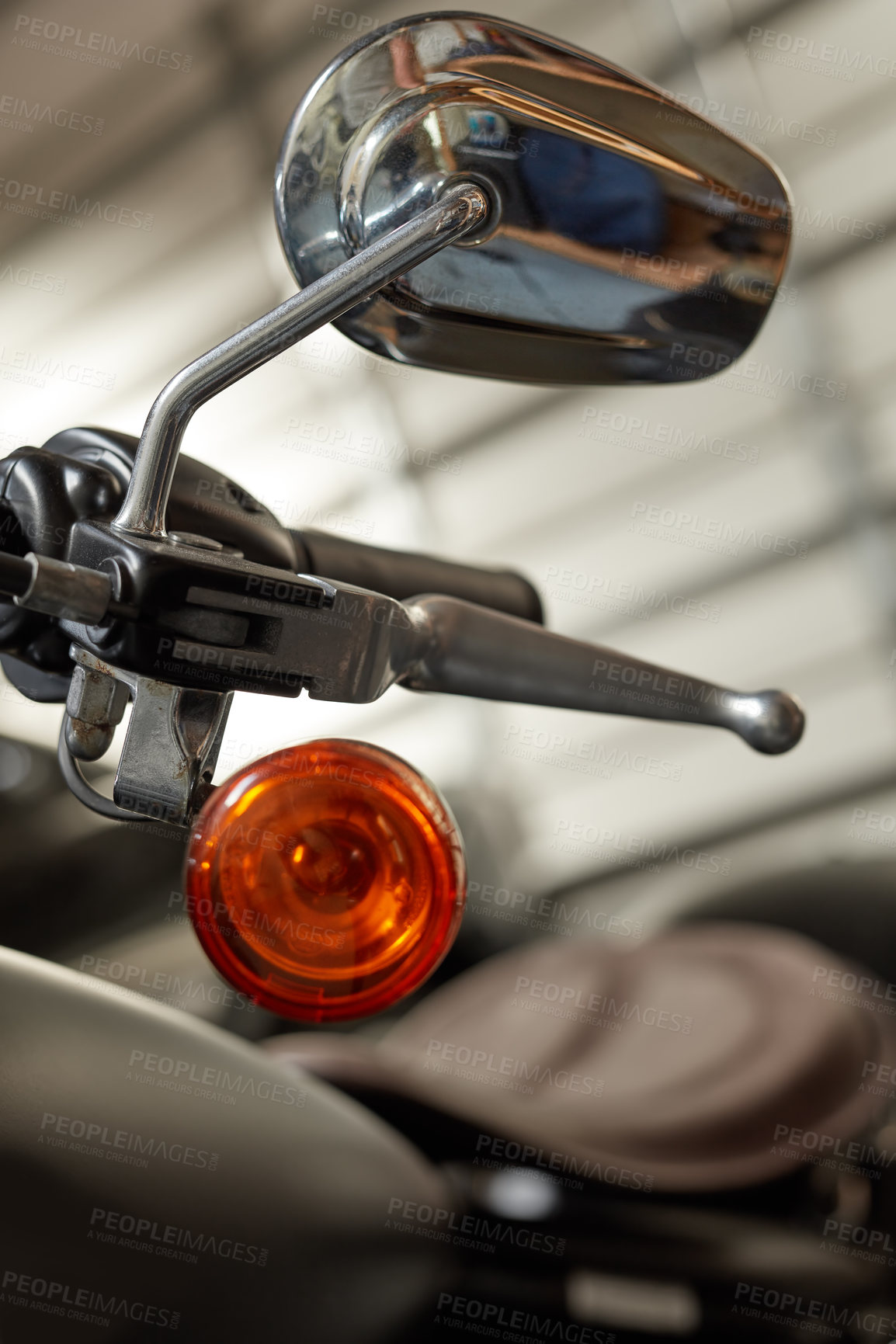 Buy stock photo Closeup of orange turning signal, light and indicator on motorbike in a mechanic garage. Stainless steel and chrome rearview mirror, brake handles and handlebar. Repairing and fixing for road safety