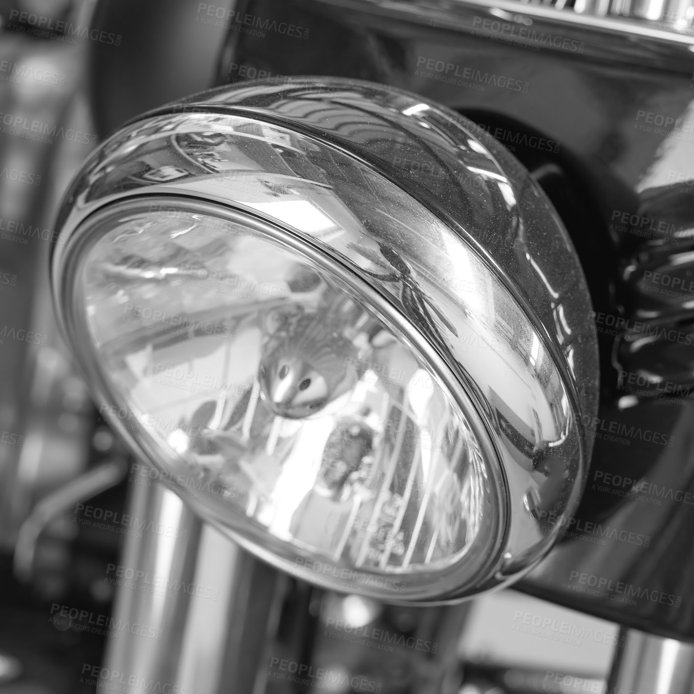 Buy stock photo Closeup of a headlight on a motorbike. Motorcycle light with black and white filter. One light bulb on a sliver modern classic chrome coated motor vehicle. Clean, sleek chromium maintenance on a bike