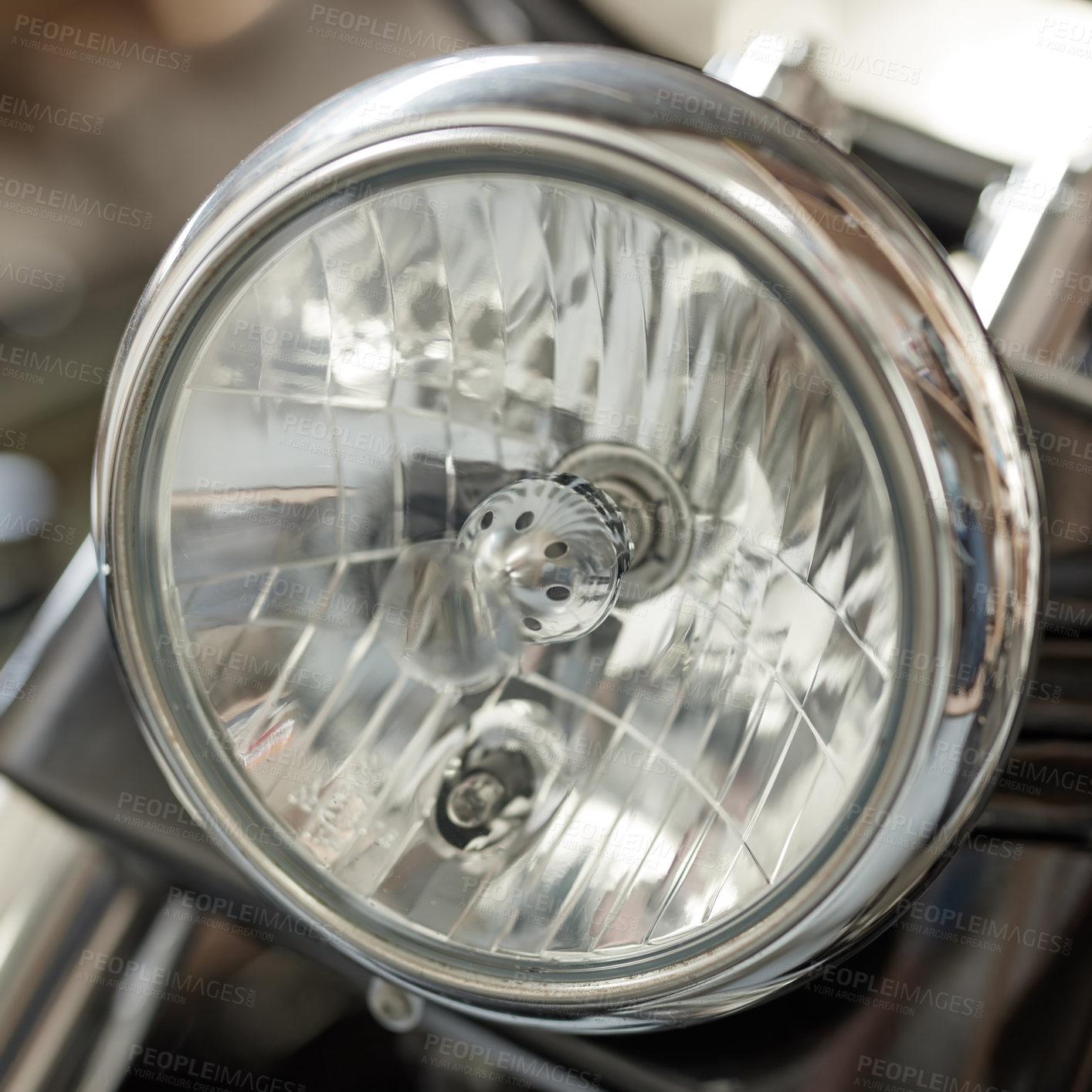 Buy stock photo Closeup of a round headlight on a classic motorbike. One light bulb on a well maintained sliver chrome coated retro motorcycle. Motor vehicle accessories and parts. Glass lamp light with silver fram