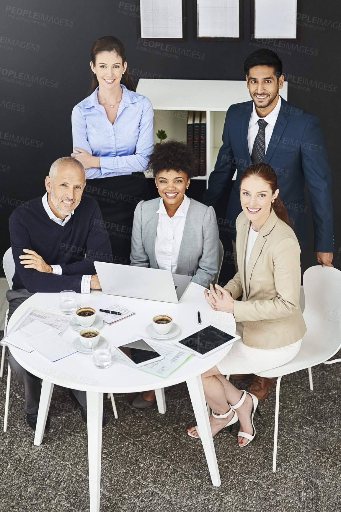 Buy stock photo Shot of a group of businesspeople gathered around a round table
