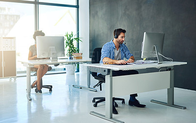 Buy stock photo Shot of two support agents working in a modern office