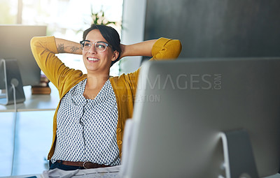 Buy stock photo Cropped shot of a young businesswoman relaxing at her desk in a modern office