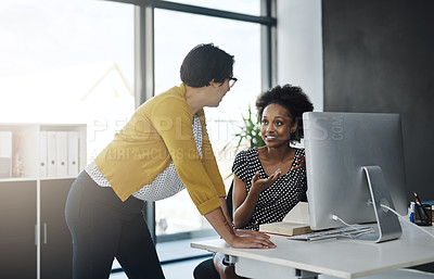 Buy stock photo Cropped shot of two young businesswomen working together in a modern office