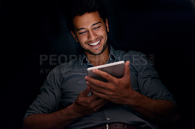 Buy stock photo Cropped shot of a young businessman working late on a digital tablet