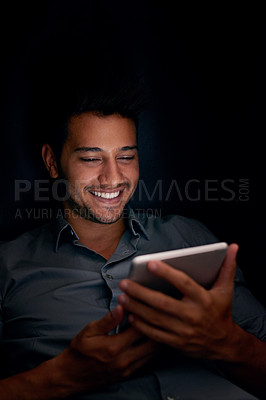Buy stock photo Happy business man, tablet and night with smile for meme, social media app or comic video on web, internet or blog. Young businessman, digital touchscreen or reading in dark workplace with funny chat