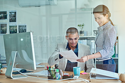 Buy stock photo Cropped shot of two businesspeople looking through some paperwork in an office