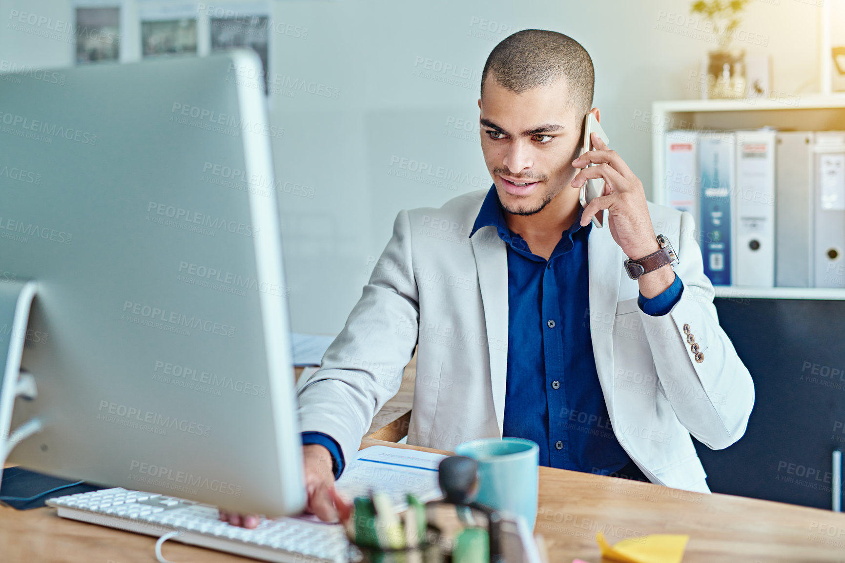 Buy stock photo Cropped shot of a young businessman talking on a cellphone in an office