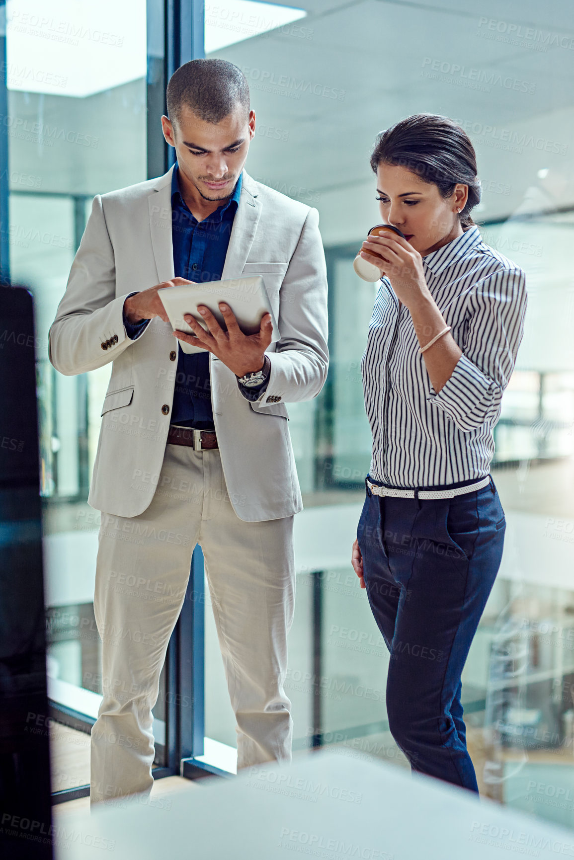 Buy stock photo Cropped shot of two businesspeople working together on a digital tablet in an office