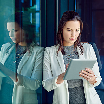 Buy stock photo Shot of a young businesswoman using a digital tablet at work