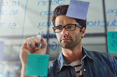 Buy stock photo Face, glass and planning with business man writing in office to brainstorm company strategy. Mindmap, mission and schedule with confident young employee in workplace for strategy on storyboard