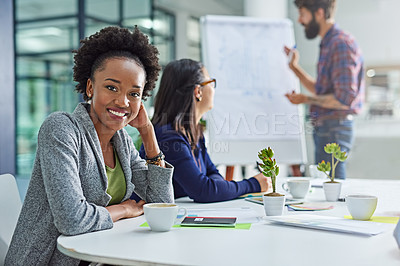 Buy stock photo Portrait of a young businesswoman sitting in a meeting with colleagues in the background
