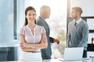 Buy stock photo Cropped portrait of a businesswoman standing in the office with her colleages in the background