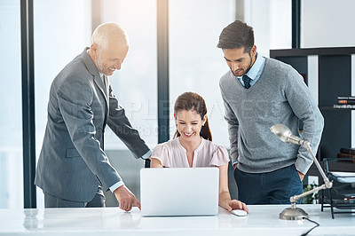 Buy stock photo Cropped shot of three businesspeople using a laptop in the office